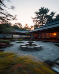 A long-exposure photograph of a serene Zen garden at sunset, showcasing motion blur in light trails, emphasizing a calm and p