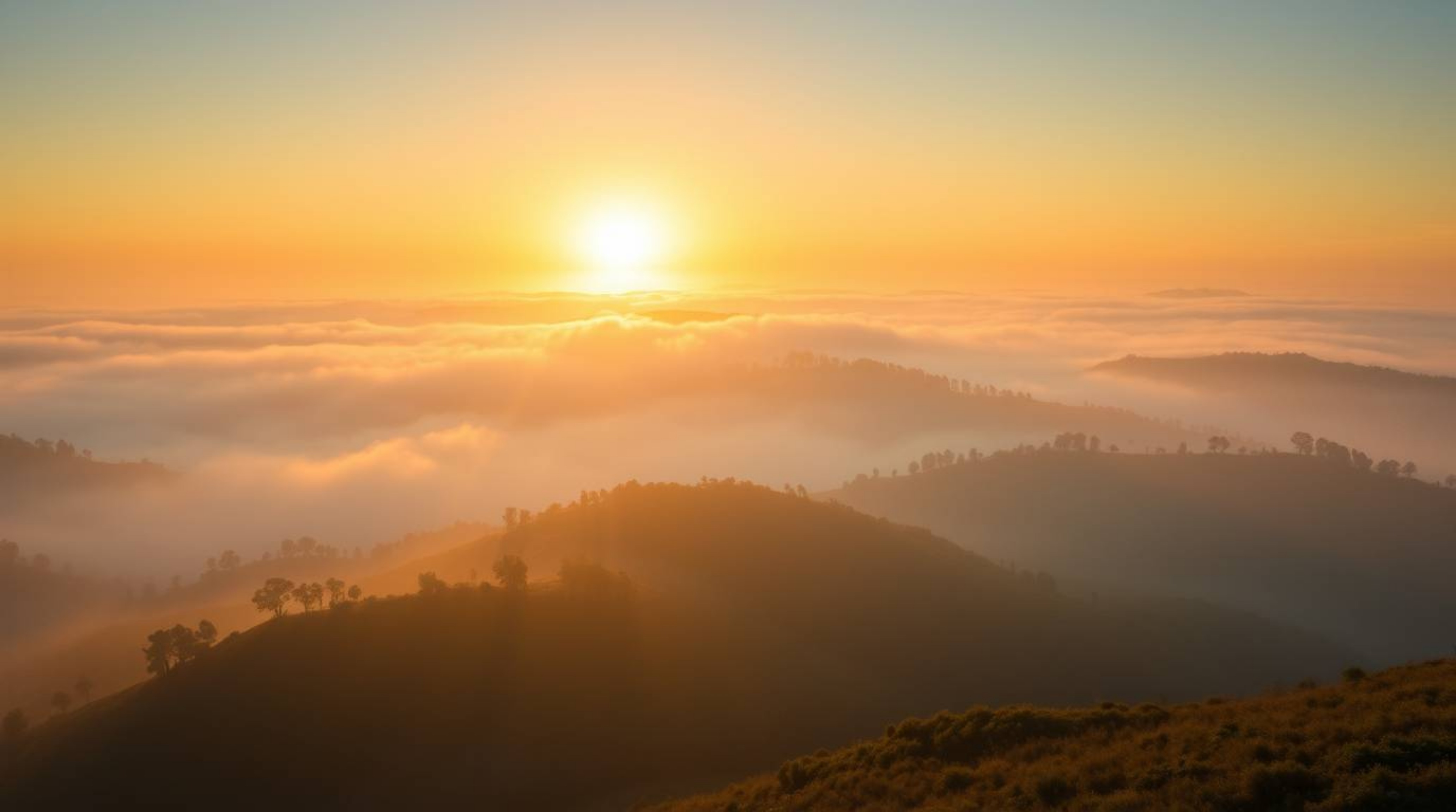 Experience the breathtaking beauty of a sunset over fog-covered hills. This stunning aerial shot captures the warm golden hou
