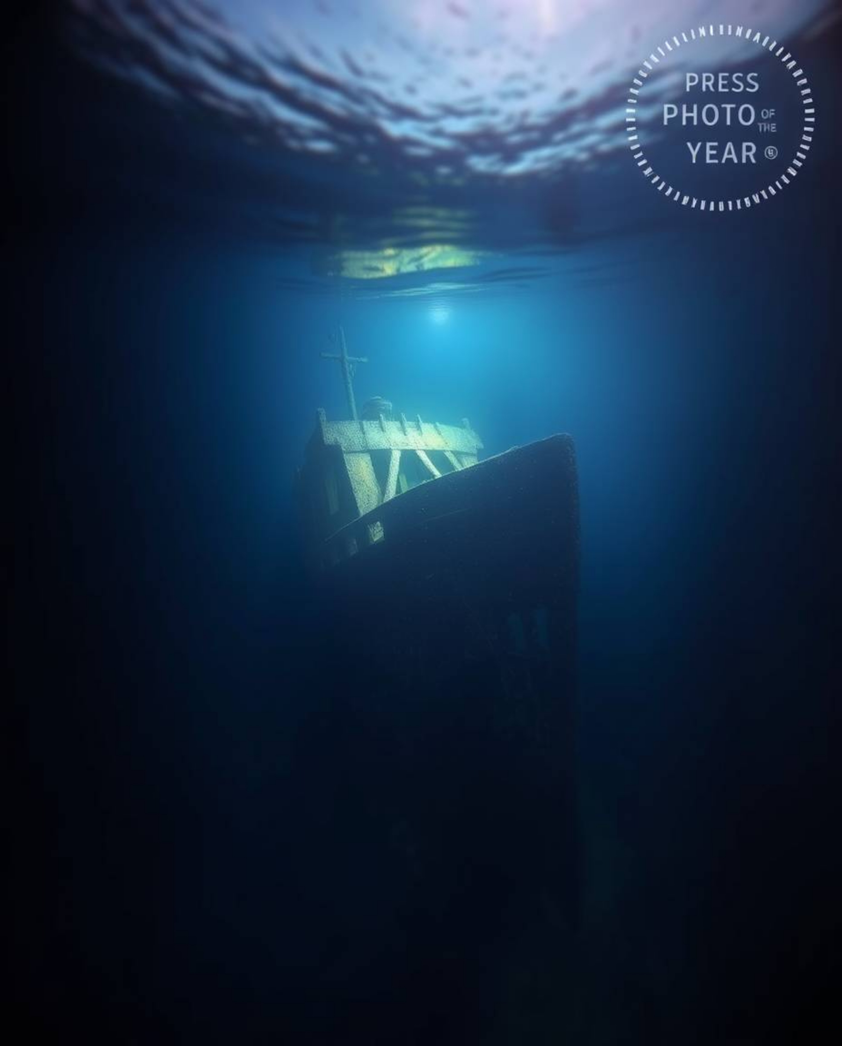 This series showcases professional photographs of a shipwreck illuminated in the deep underwater. The images feature divided 