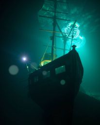A mesmerizing creative light art piece depicting a shipwreck illuminated deep underwater, rendered in rich, deep teal colors.