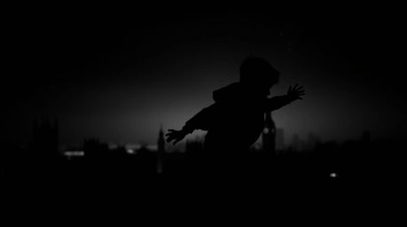 A captivating image featuring a young boy silhouetted against the London skyline, seemingly flying with the aid of barely vis