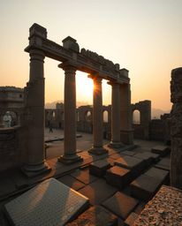 Precise architectural color photography captures a sunset casting shadows through ancient stone ruins. The image is character