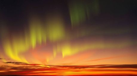 Experience the ethereal beauty of the Northern Lights dancing across a vibrant sunset sky. This abstract artwork captures the