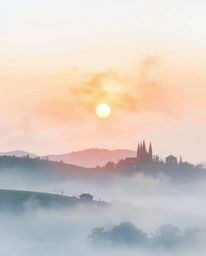 This is a delicate watercolor painting of a sunset over misty Tuscan hills. The artwork is characterized by a soft cinematic 