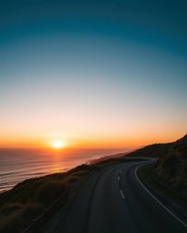 This artwork presents an extreme macro close-up of a scene inspired by a sunset sky over a winding coastal highway. It featur