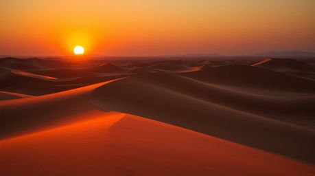 Experience the breathtaking beauty of a desert sunset where golden dunes meet the horizon.  Rendered with iridescent colors a