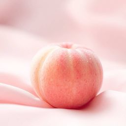 A high-resolution, close-up ASMR image showcases a soft pink peach, delicately fuzzy and adorned with glistening condensation