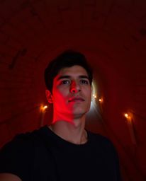 A captivating image depicts a person silhouetted at a tunnel's entrance, gazing towards a radiant light source.  Warm candlel