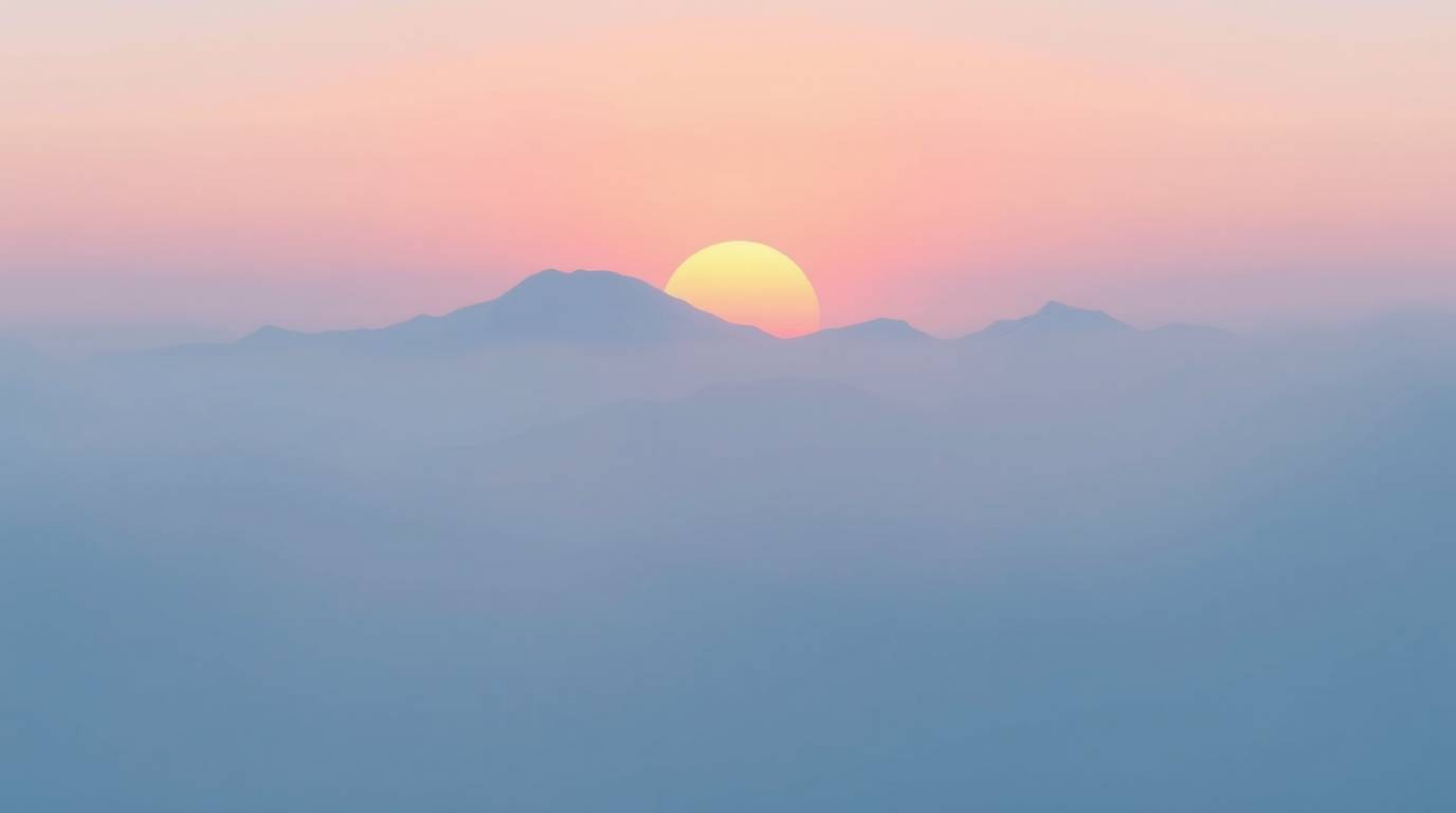 A flat, two-dimensional depiction of snow-covered mountains illuminated by a pastel sunset, shrouded in a thick fog. The desi