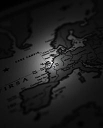 An extreme macro close-up reveals a captivating, glowing map within the confines of an old study, rendered in classic black a