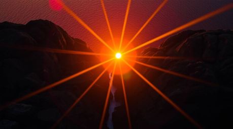 Experience the breathtaking beauty of a vibrant sunset over dramatic cliffs and crashing waves. This stunning aerial shot cap
