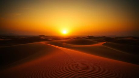 A stunning high-resolution stock photo depicting a vibrant sunset over golden desert dunes.  The image showcases bioluminesce