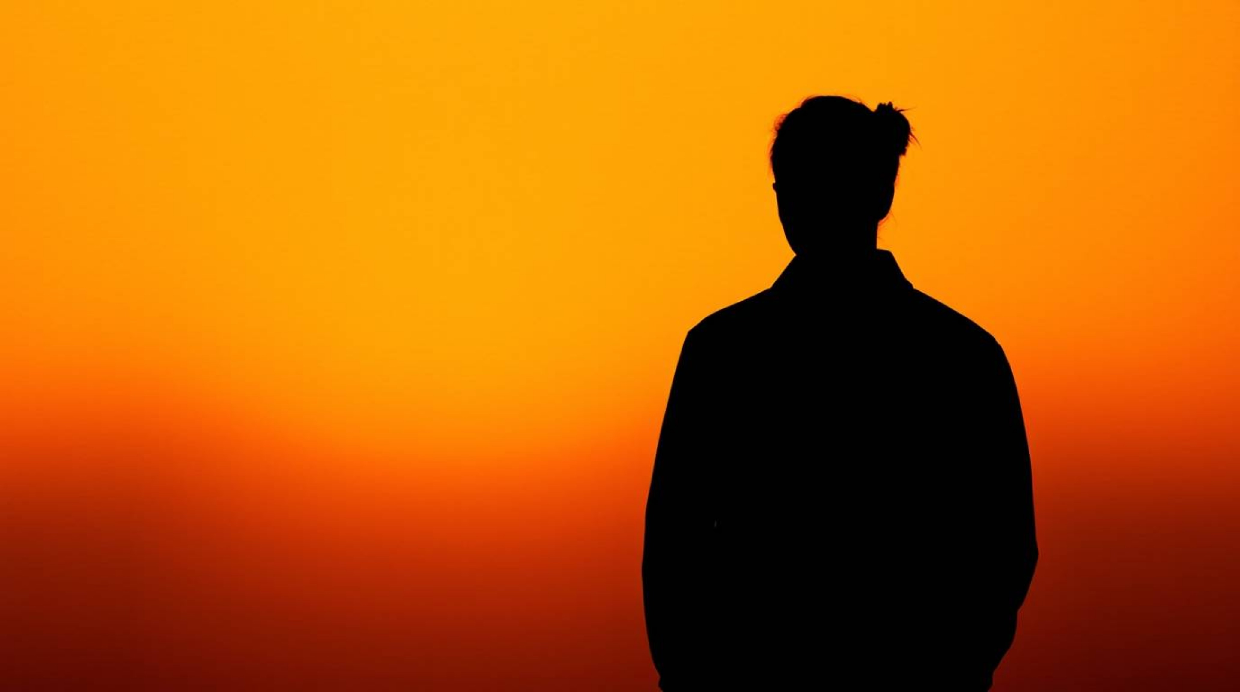 Explore stunning visuals featuring a silhouetted figure against a warm autumnal gradient background, enhanced by a subtle pap
