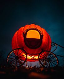 A captivating low-angle photograph depicts a magical pumpkin undergoing a breathtaking transformation into a carriage. This v