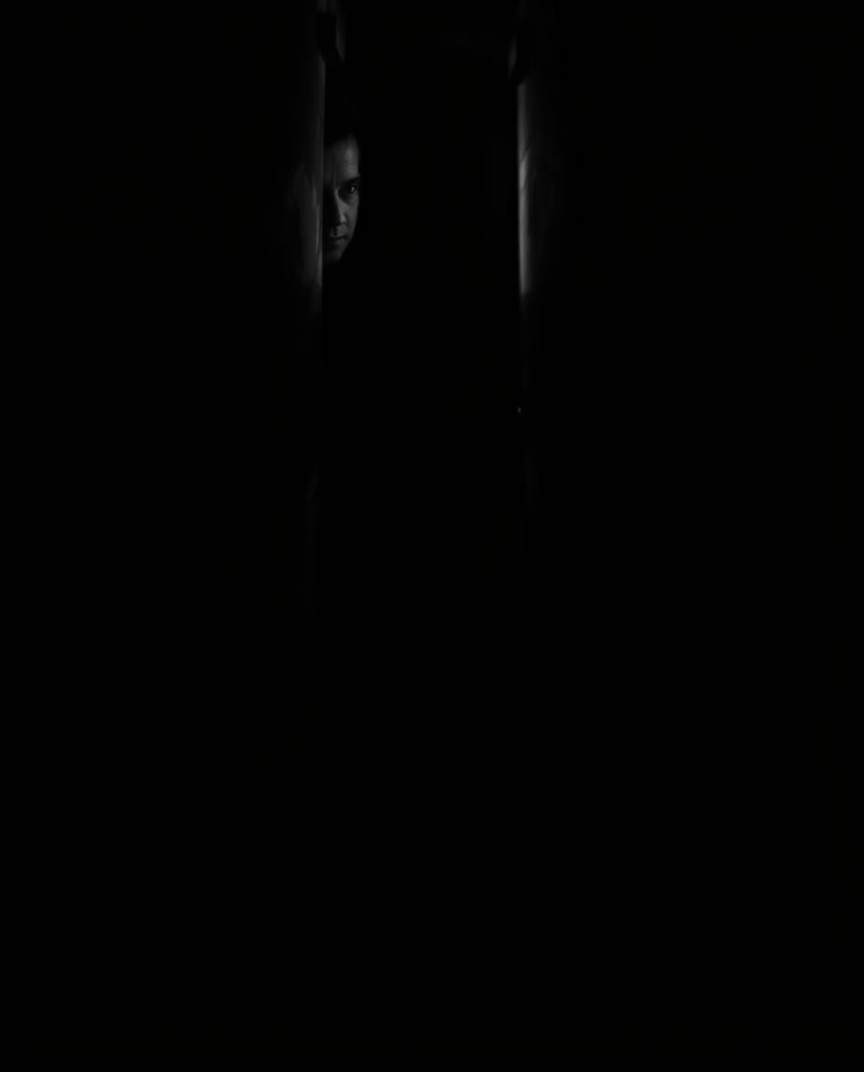 A captivating black and white photograph featuring chiaroscuro lighting, creating a dramatic contrast between light and shado