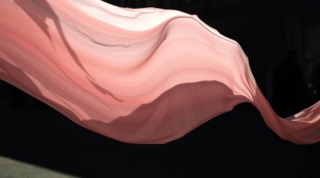 This captivating street photograph captures a fluid, abstract wave with a pastel gradient texture, bathed in harsh, direct su