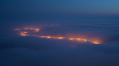A stunning high-resolution stock photo depicts a river delta bathed in the ethereal glow of twilight.  Thick fog shrouds the 