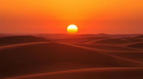 Experience the breathtaking beauty of a sunset over golden desert dunes.  This stunning image showcases a smooth gradient tra