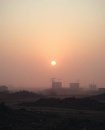 A serene and subtly melancholic image depicts a sunrise over a war-torn landscape, rendered in soft pastel colors and a cinem