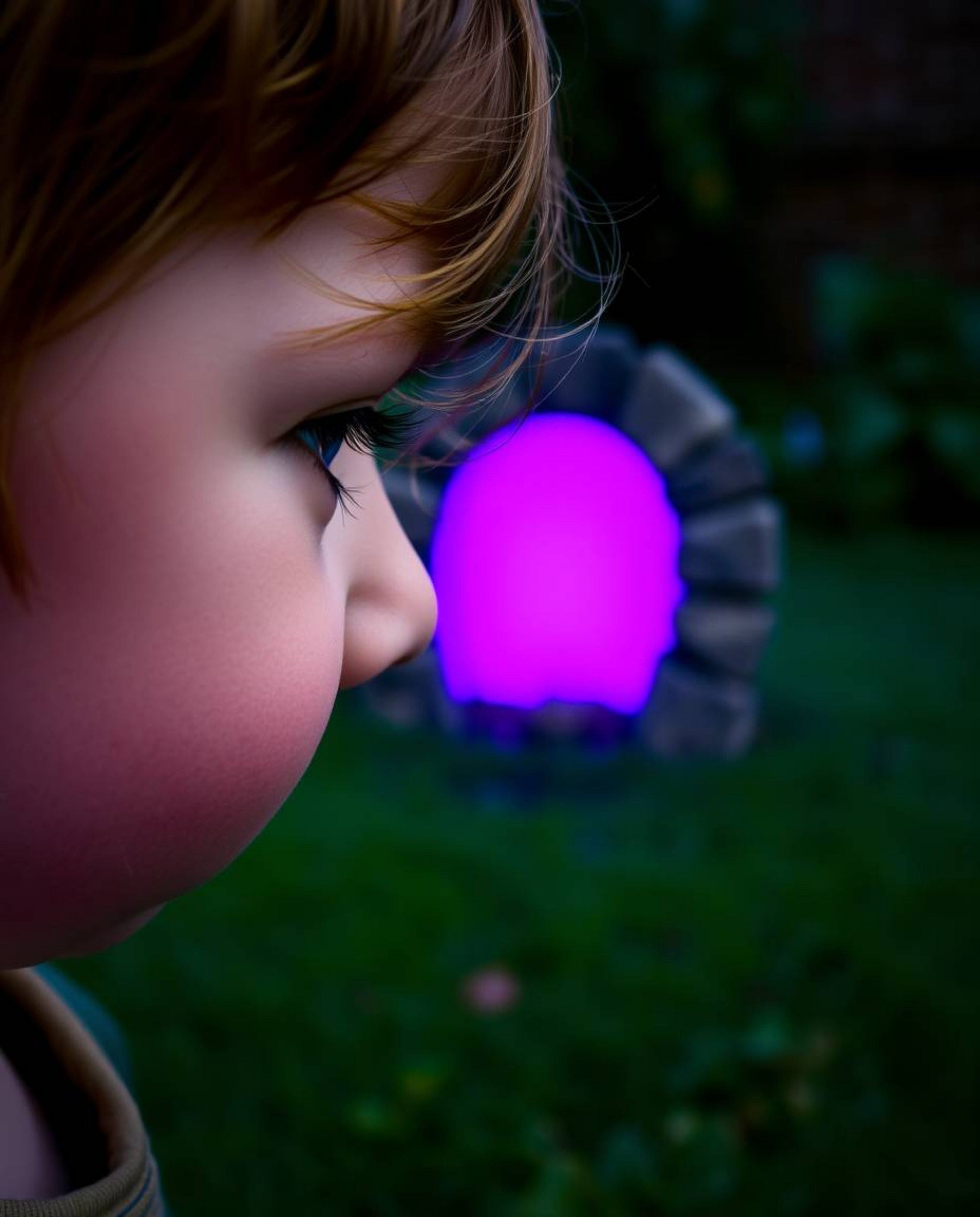 A captivating close-up captures a child's astonished face as they discover a vibrant purple portal in their backyard. The sce