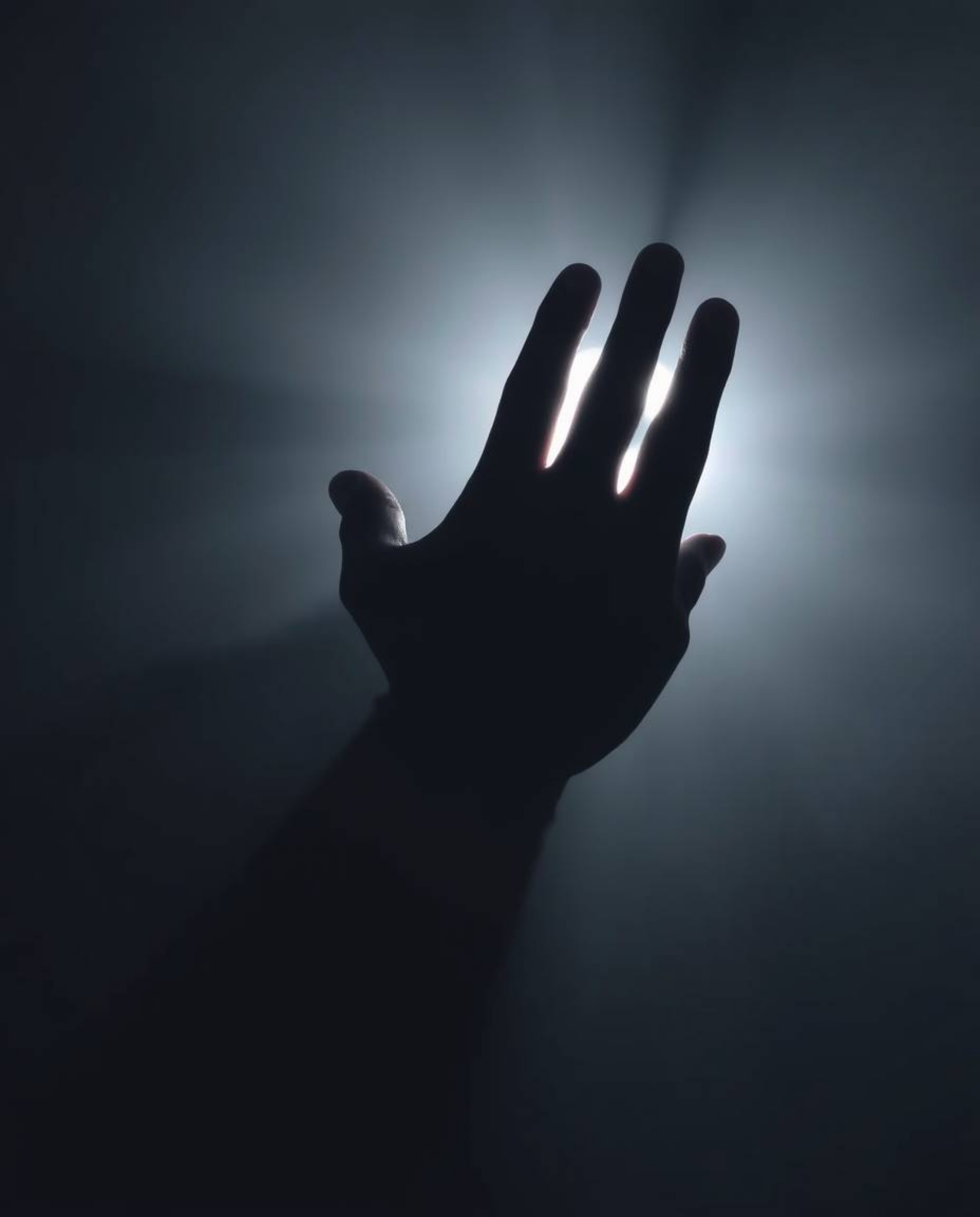 A captivating and ethereal image depicting a hand reaching towards a hazy light emerging from darkness, bathed in soft light.
