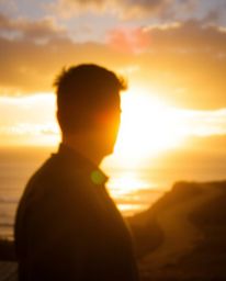 A stunning silhouetted photograph captures a sunset sky over a winding coastal highway. This composition is defined by its us