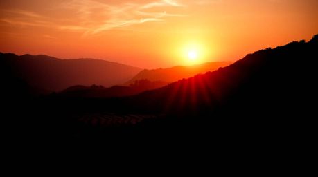 Capture the breathtaking beauty of a high-contrast sunset over stunning rice terraces. This scene showcases deep shadows, dra