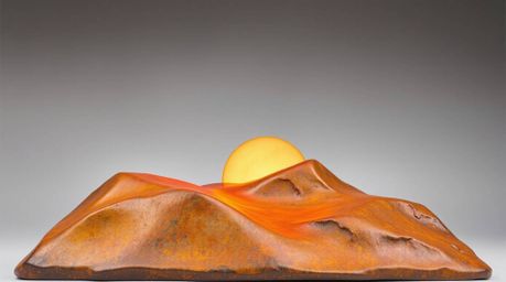 A captivating bronze sculpture depicting a vibrant sunset over golden desert dunes.  Finished with an antique patina, this li