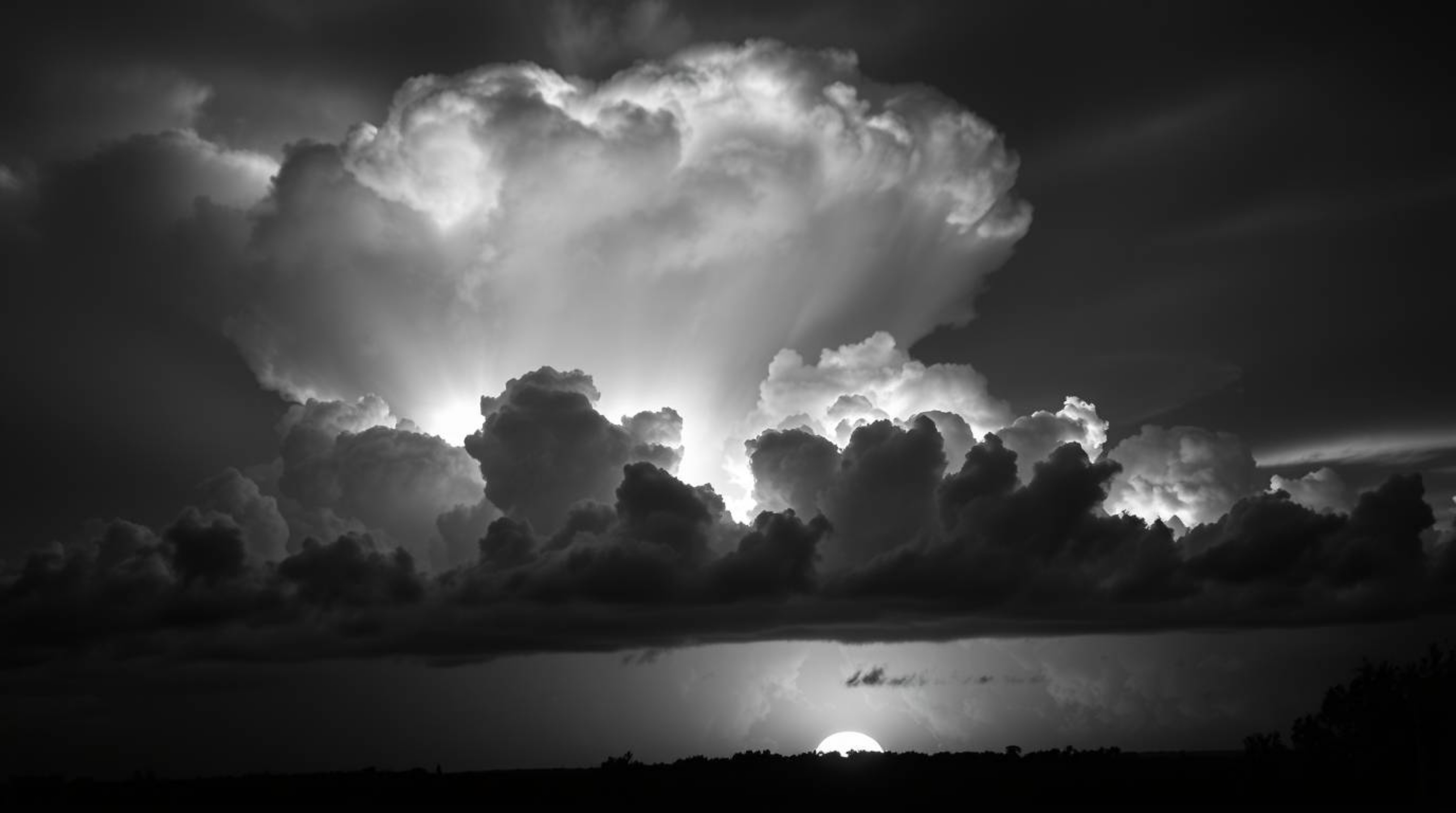 A captivating piece of creative light art depicts dramatic thunderstorm clouds brilliantly illuminated by the warm glow of a 