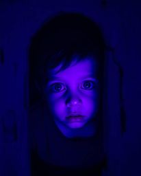 A young child stumbles upon a mysterious portal hidden in their backyard, bathed in eerie deep ultraviolet hues. The scene i