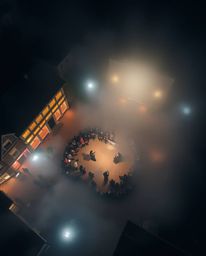 Experience a captivating overhead bird's-eye view of a vibrant musical number unfolding in a brightly lit town square. The sc