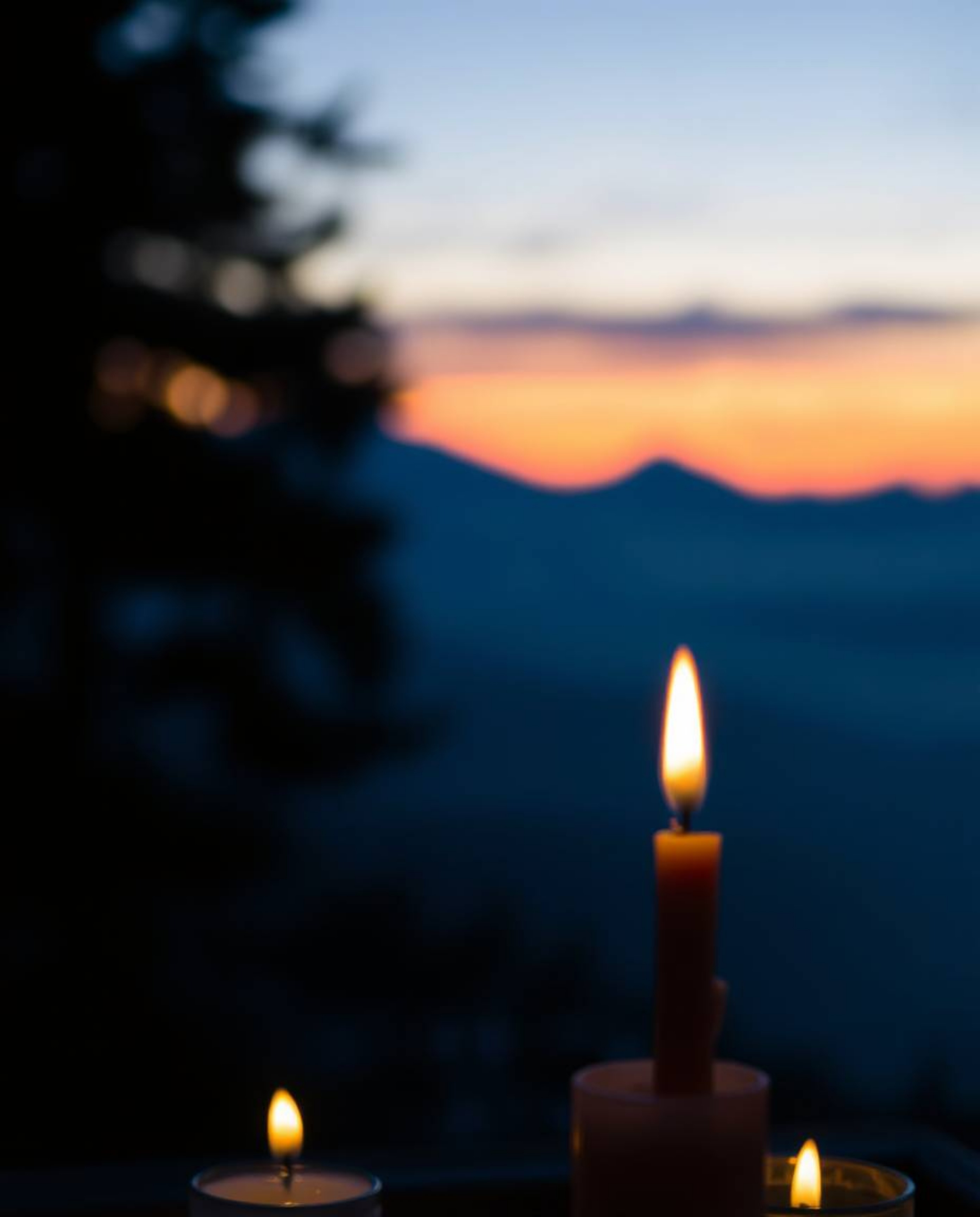 Experience the enchanting ambiance of a warm, candlelit scene capturing a sunset from a high alpine peak. This image creates 