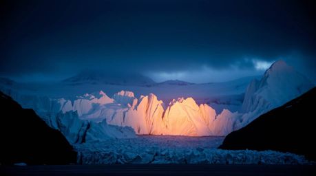Experience the breathtaking beauty of a sunset over icy glaciers in the polar region.  High-contrast, low-key lighting create