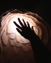 This captivating artwork depicts a silhouetted hand reaching towards light from the darkness, rendered in soft pastel colors 