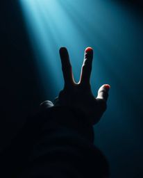 A captivating image depicts a hand extending towards a source of light emerging from the darkness.  Rendered in cool colors a