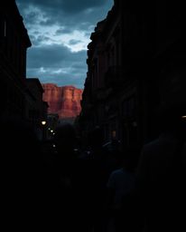 In the style of candid street photography, this moody image captures a sunset illuminating sandstone canyon cliffs, uniquely 