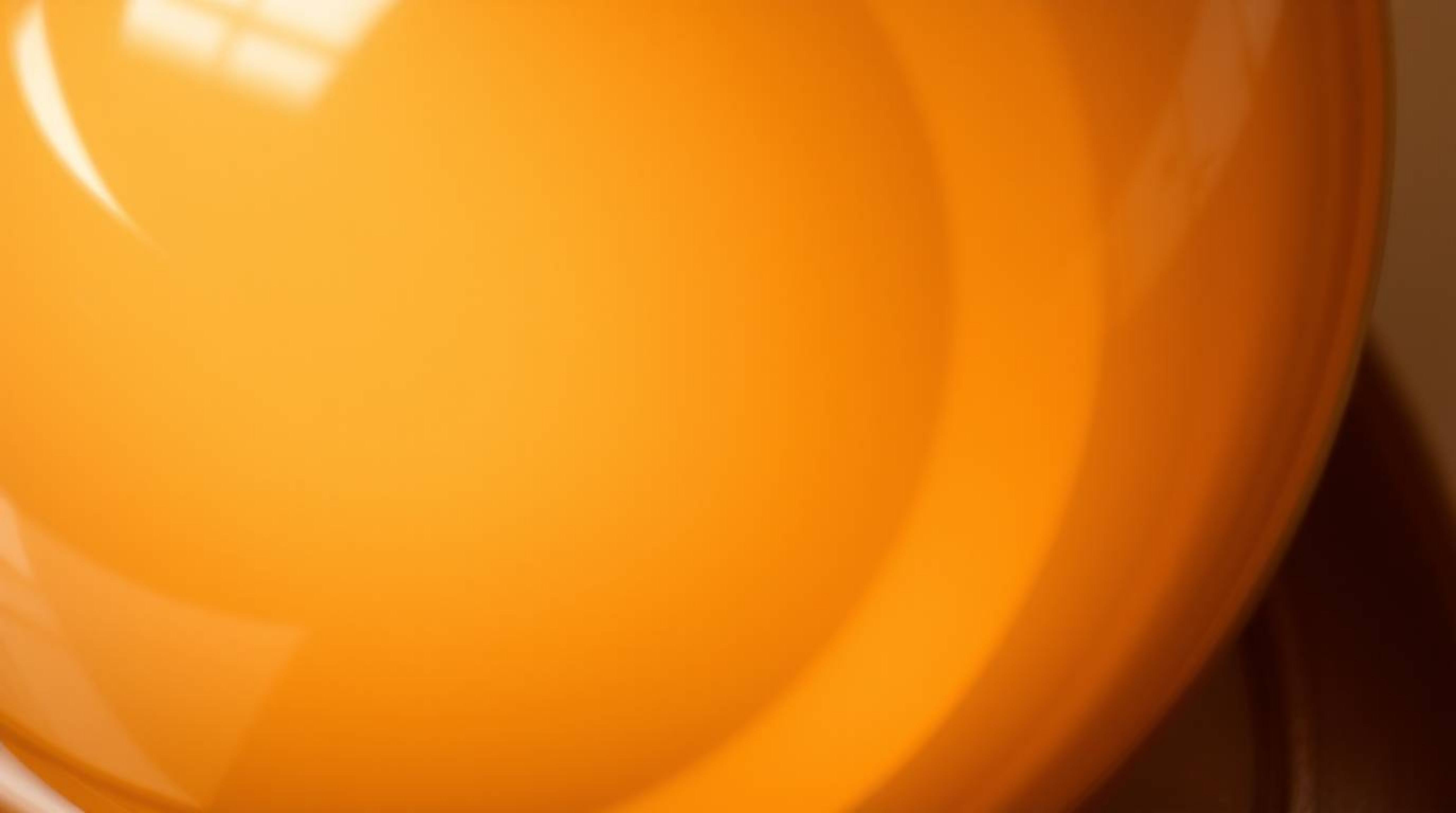This image showcases a high-angle, close-up detail shot of a glass object, masterfully reflecting smooth gradient textures in