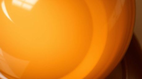 This image showcases a high-angle, close-up detail shot of a glass object, masterfully reflecting smooth gradient textures in
