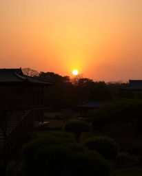 Warm-toned, high-resolution fine art photograph of a graceful and elegant sunset over a serene Zen garden; soft contrast, sof