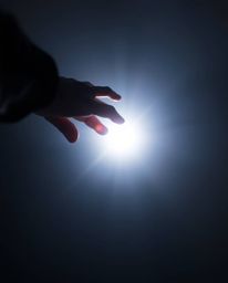 This image depicts a hand reaching towards light from darkness in a modern flat design style, captured from a high angle. The