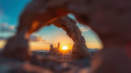 Experience a dreamlike and surreal sunset scene captured through a natural rock arch in the desert. The image features a shar