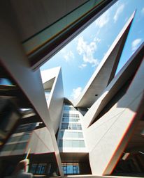 A dynamic architectural color photograph showcasing abstract shapes with striking glitch effects, fragmentation, and scanline