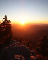 Bask in the beauty of a warm golden hour image, capturing a sunset from a high alpine peak. This scene is bathed in the soft 