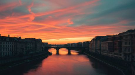 Explore stunning architectural photography capturing a winding river illuminated under a dramatic orange-pink sky. This image