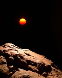 This sculptural clay artwork depicts a sunset from a high alpine peak, dramatically illuminated by strong, hard light. The pi