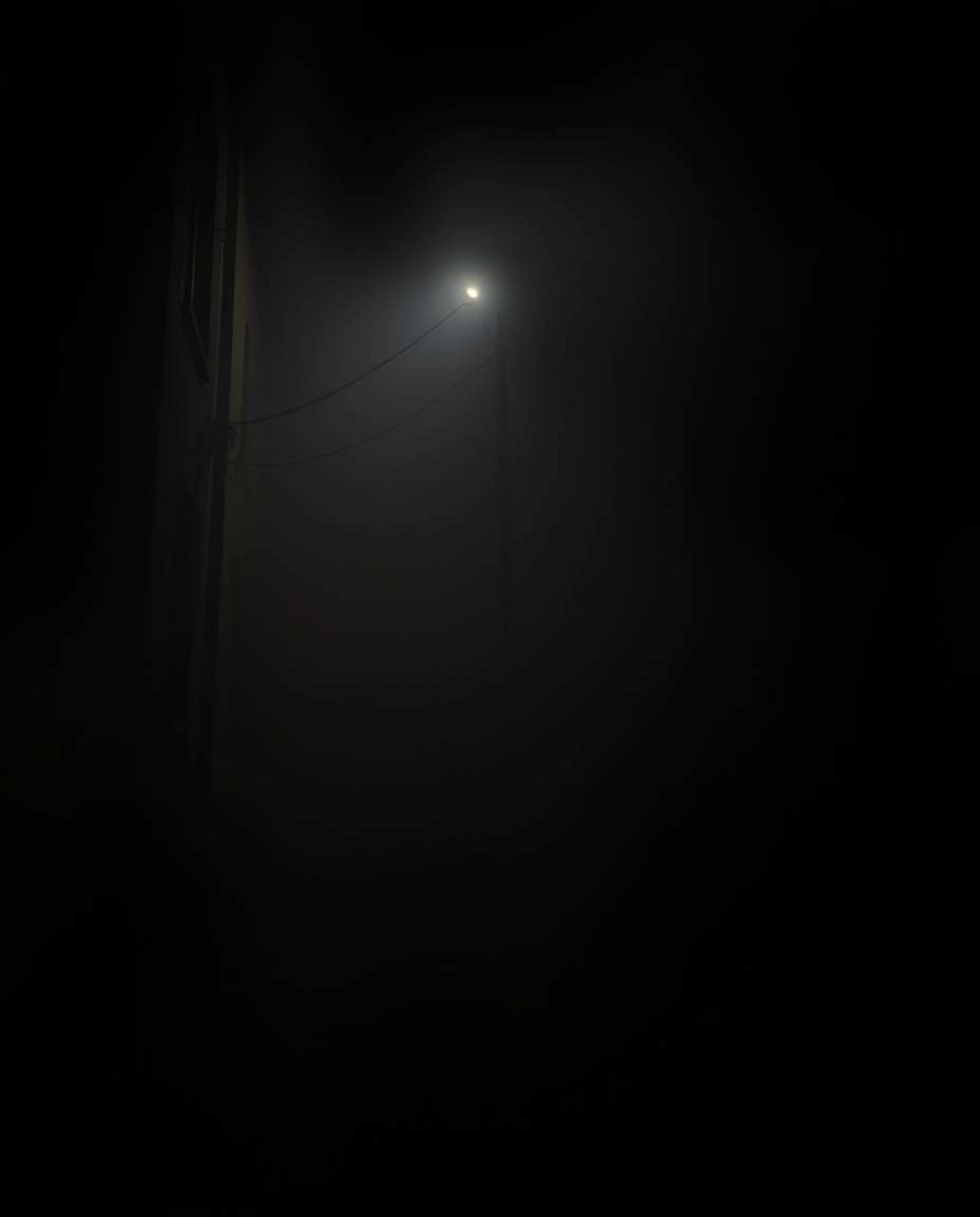 Capture the mysterious ambiance of a night alley with this high-resolution stock photo. Thick fog hangs heavy, obscuring visi