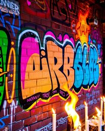 Experience the dynamic energy of vibrant graffiti art splashed across a brick wall. This street art scene features bright col