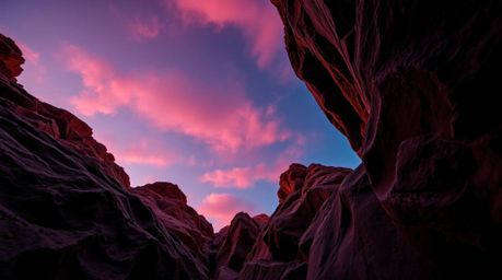 Experience the breathtaking beauty of a rocky canyon awash in the vibrant hues of a burgundy and deep blue sunset. This drama