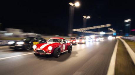 Capture the thrill of a wacky racing scene with this long exposure photograph. The image features outlandish cars speeding al