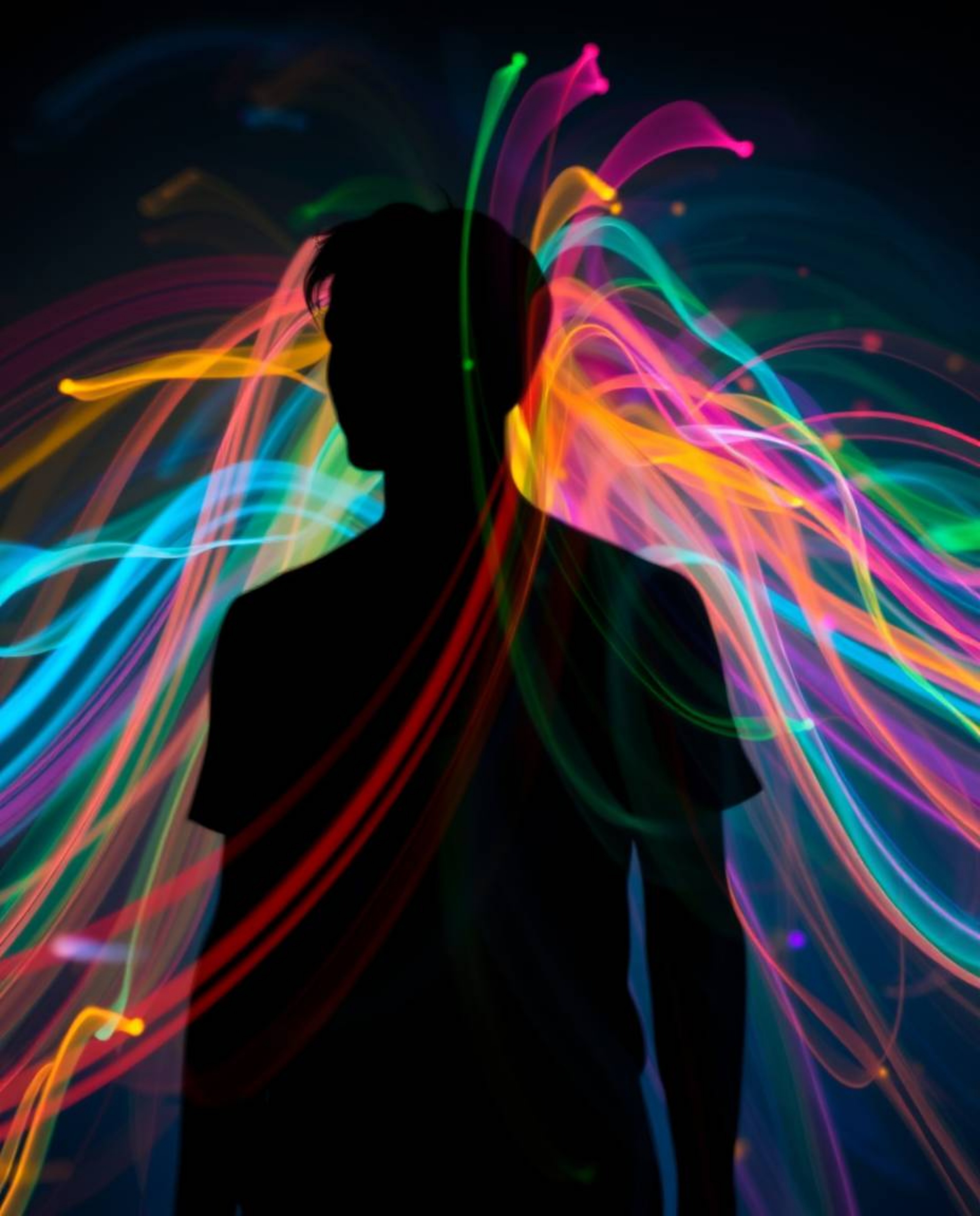 This stunning long exposure photograph captures a human silhouette formed from vibrant and dynamic colorful splash patterns. 